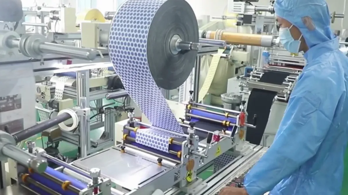 Operator running the roll-to-roll converting line for samples
